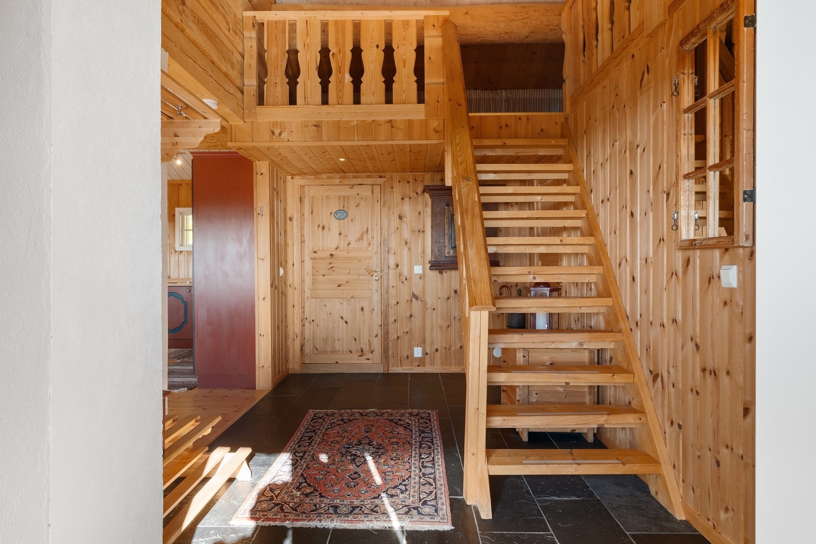 Romslig entré med trapp opp til hemsen. Galleribilde
