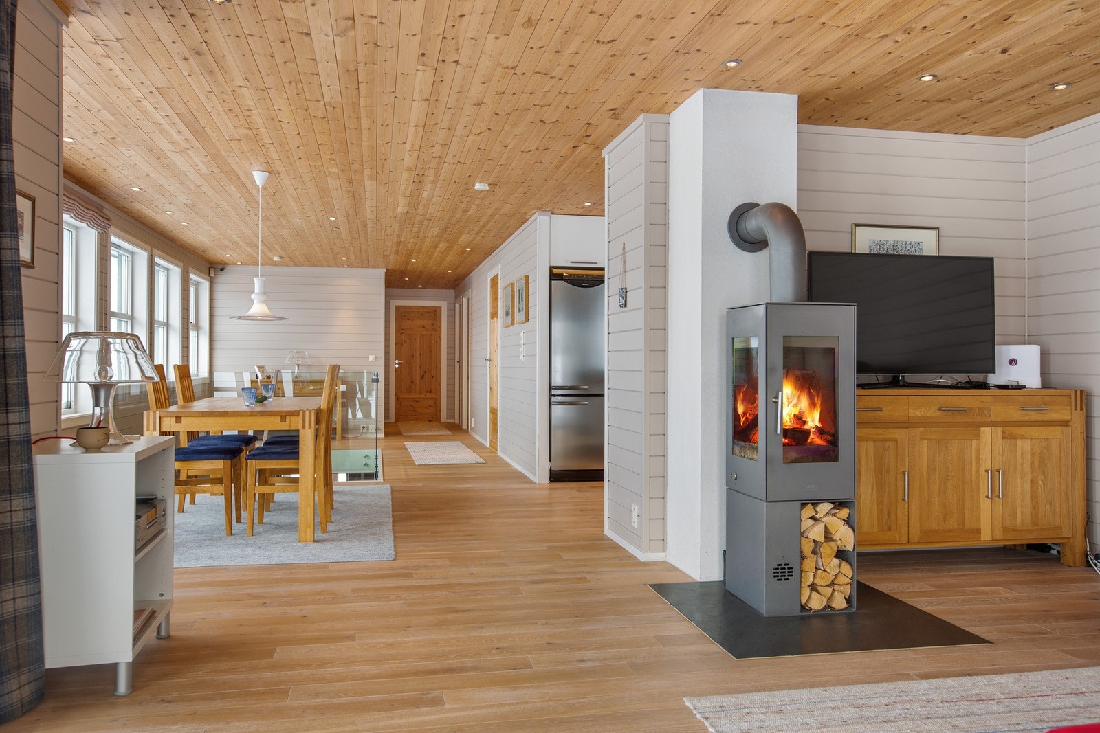 Stue og kjøkken i en åpen løsning. En innbydende og sosial utforming som gir god flyt mellom matlaging og oppholdsrom. Galleribilde