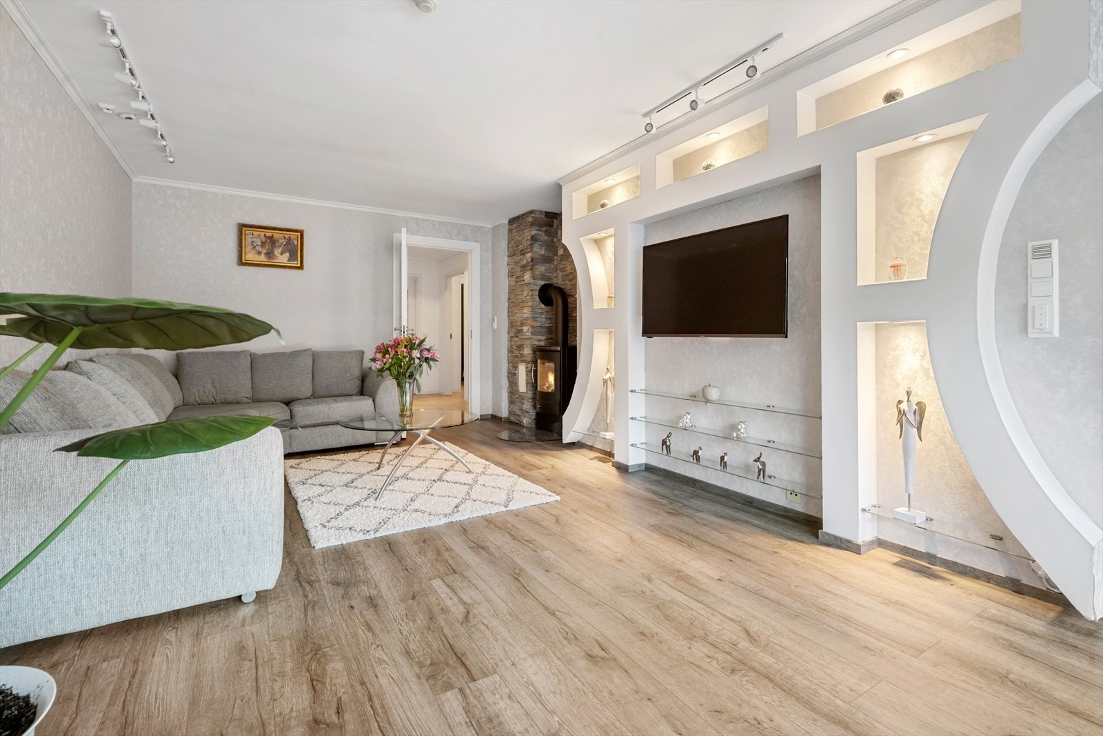 Plassbygde hyller med god plass til tv og vedomn med skiferbelagt pipe Galleribilde