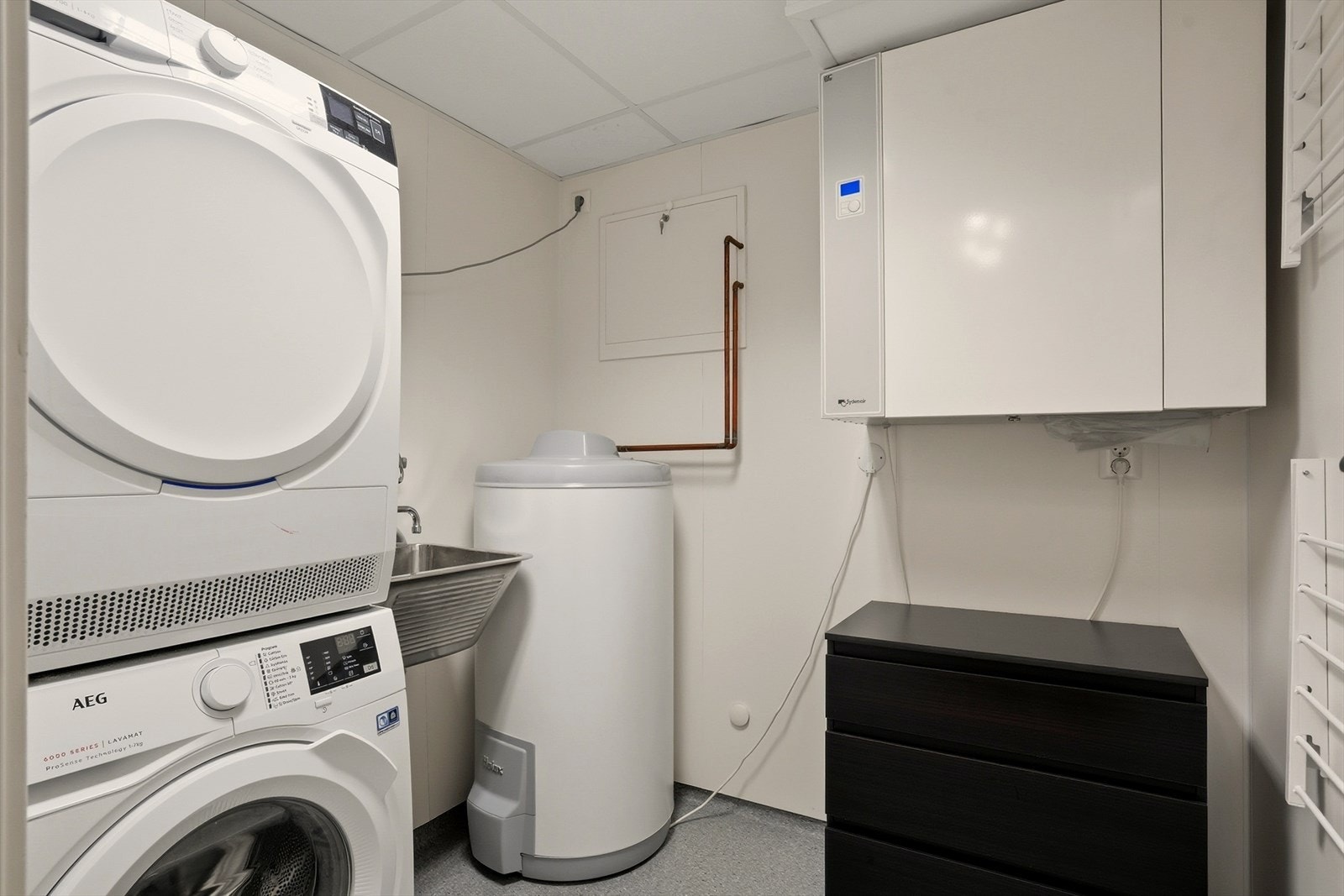 Praktisk innredet vaskerom med utslagsvask og rommet har opplegg for vaskemaskin og tørketrommel. Galleribilde