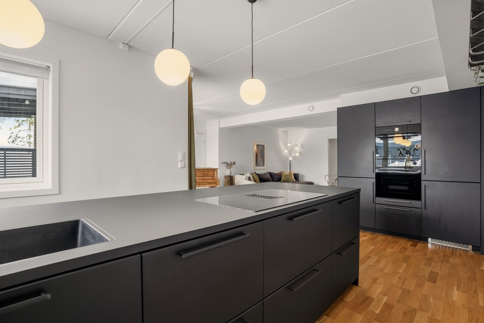 De integrerte hvitevarene og rene linjene understreker det moderne uttrykket, mens belysningen over øya gir både et stemningsfullt lys og et stilsikkert blikkfang. Galleribilde