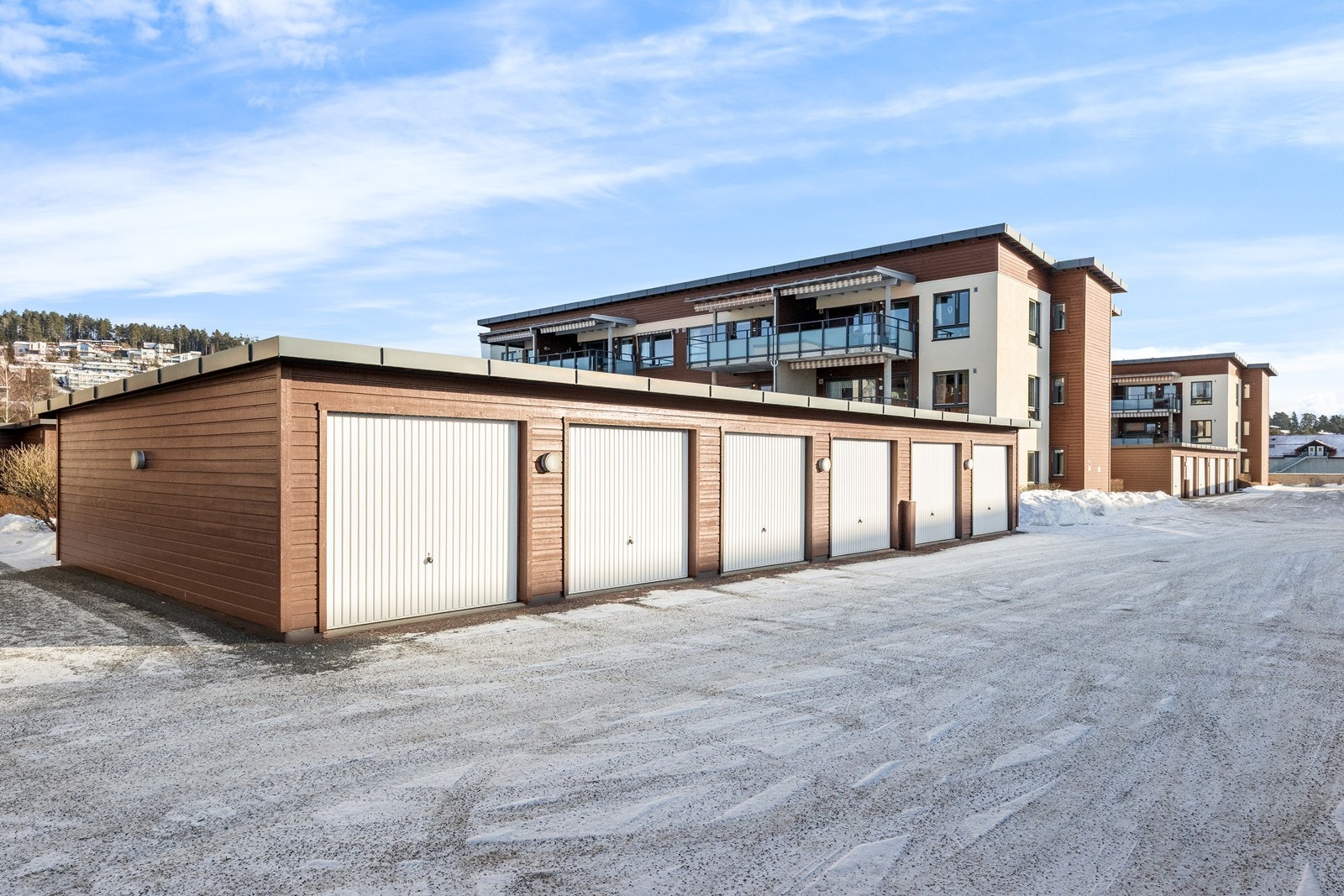 Garasjeanlegget har flere enheter med automatisk vippeport, og ligger i tilknytning til leilighetsbygget. Garasjen til leiligheten ligger på yttersiden av garasjeanlegget. Galleribilde