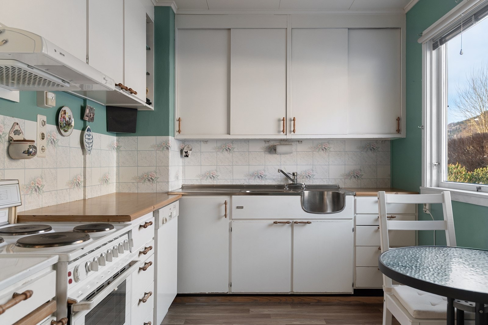 Kjøkkenet har eldre kjøkkeninnredning med slette fronter og laminat benkeplate. Galleribilde