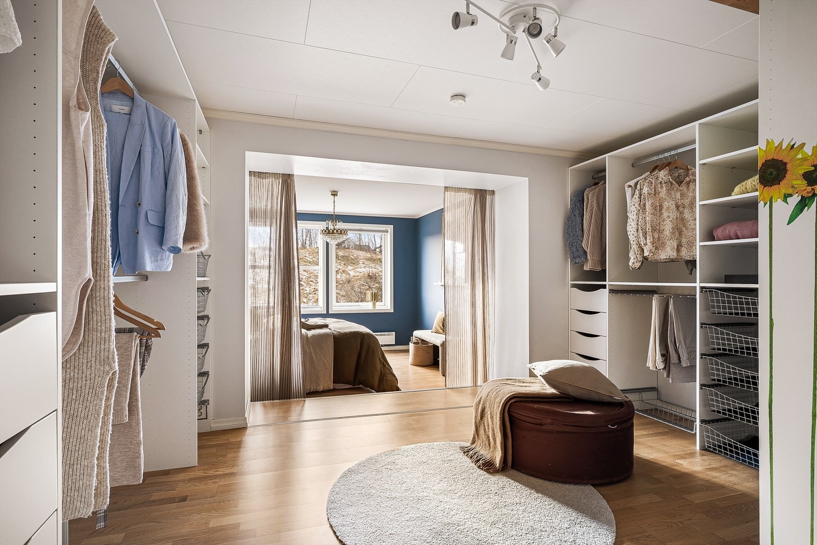 Romslig walk-in-garderobe med direkte tilgang til soverommet. Med praktisk oppbevaringsløsninger for klær og sko. Perfekt for organisering. Galleribilde