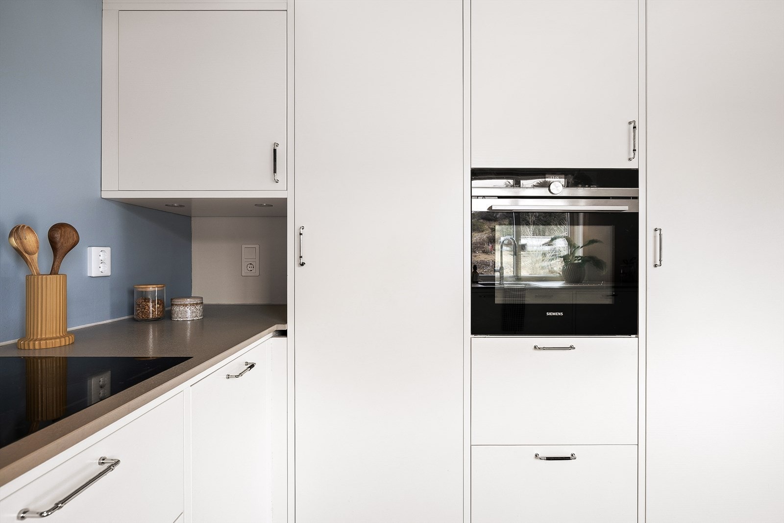 Moderne kjøkken med integrerte hvitevarer og stilrene detaljer. Stekeovn, platetopp, oppvaskmaskin, kjøleskap og fryseskap er integrert. Galleribilde