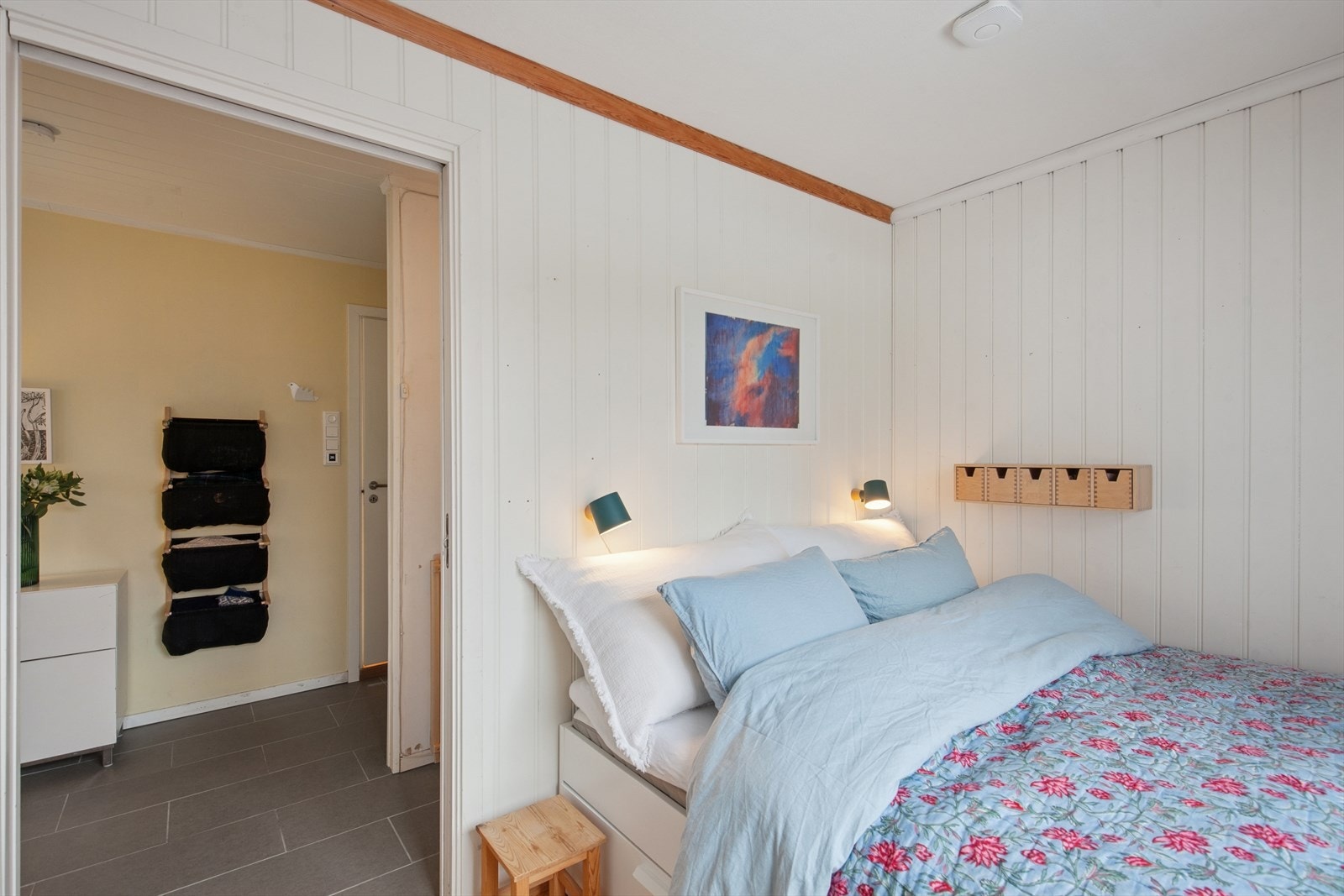 Hovedsoverommet er lyst med malt panel på vegger og parkett på gulvet. Galleribilde