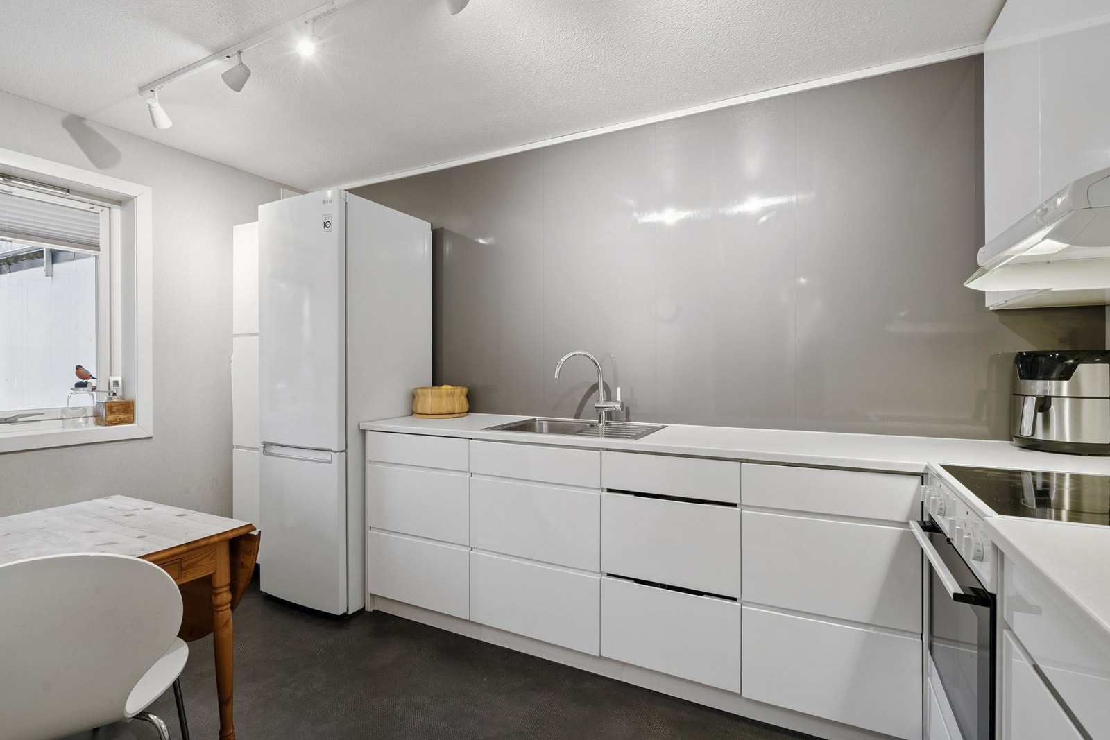 For man kommer inn i stuen ligger kjøkkenet inn til venstre. Kjøkkenløsning fra 2014 med innredning fra Kvik med høyglans fronter. Galleribilde