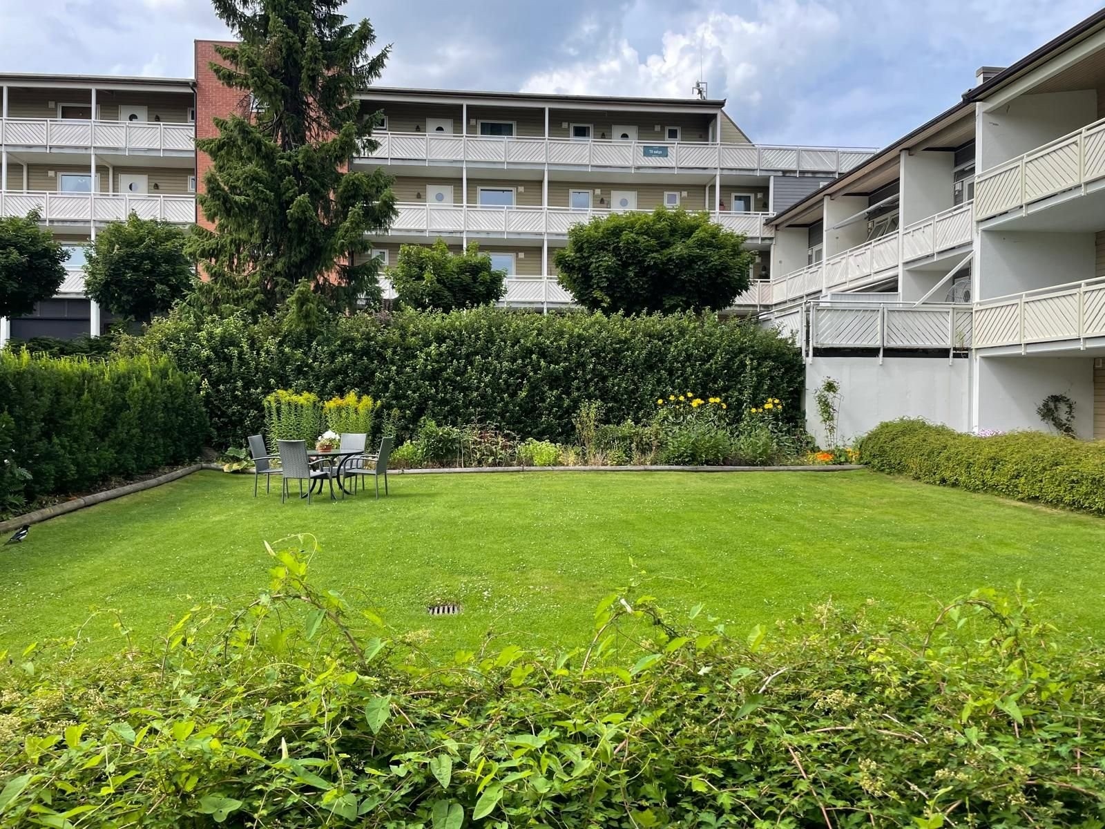 Vakker og rolig felleshage i sentrum med et utvalg av blomster og sangfugler. Galleribilde