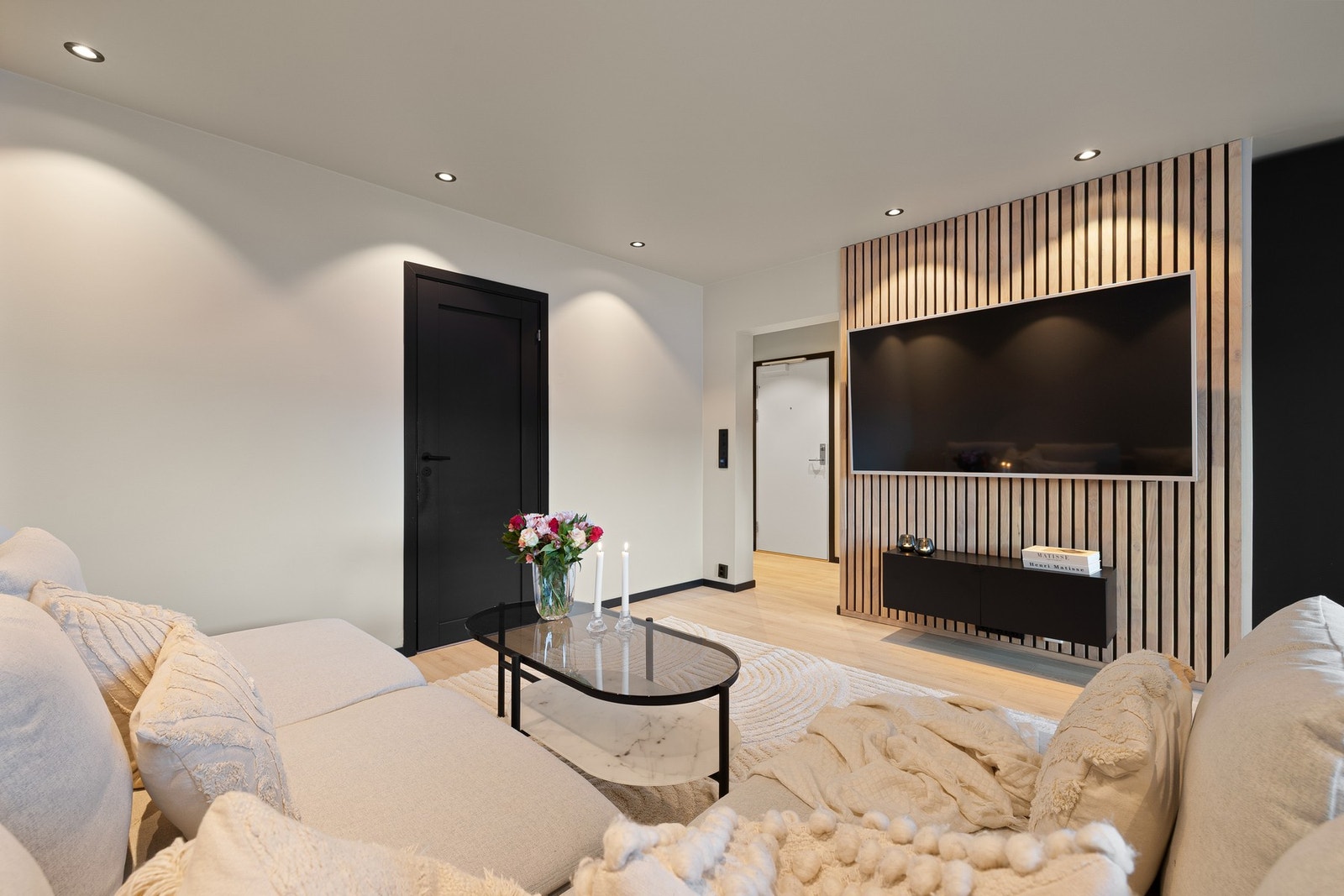 Leiligheten har gjennomgående sorte detaljer, moderne farge- og materialvalg samt en dekorativ spilevegg på stuen. Galleribilde