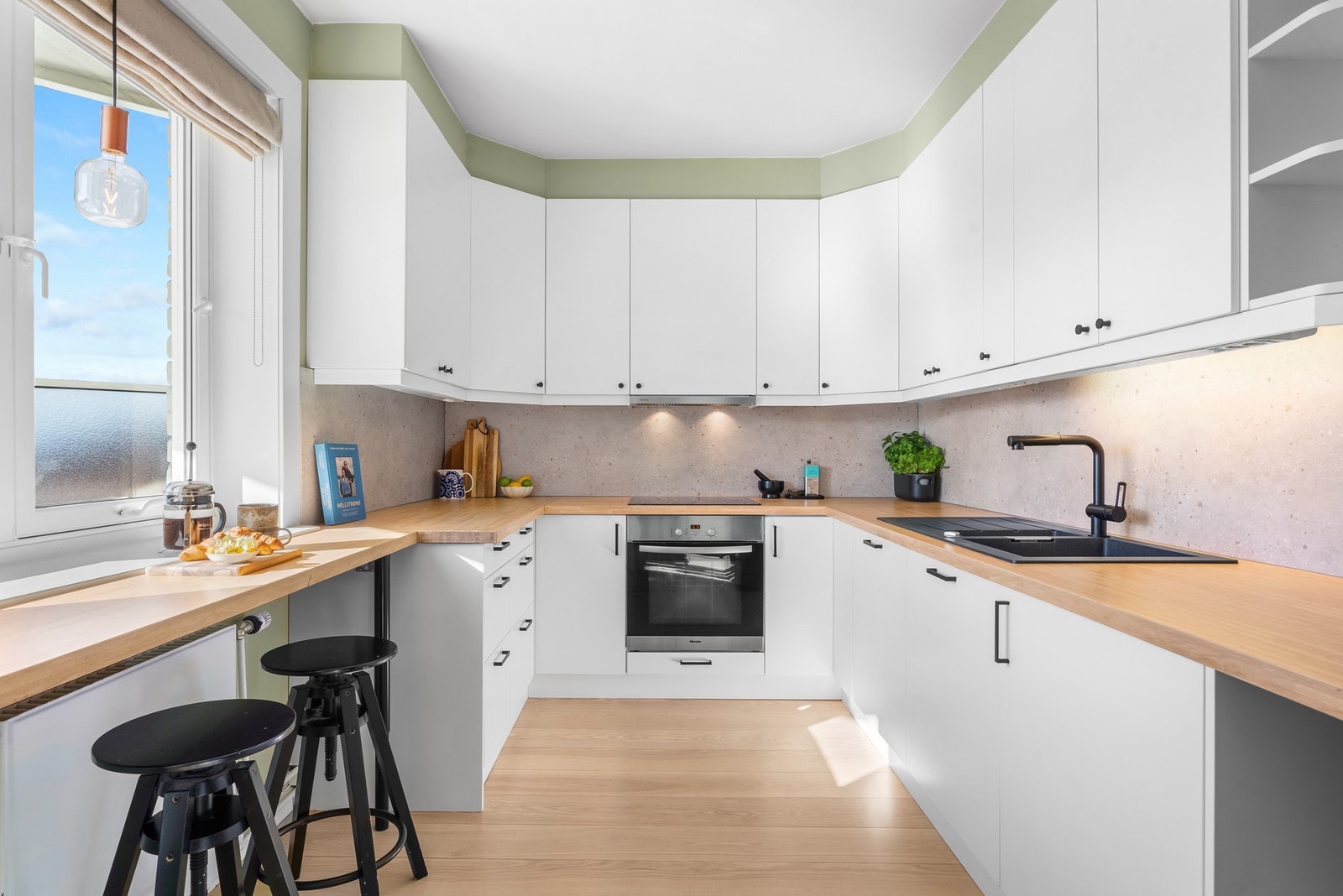 Lyst og innbydende kjøkken med integrerte hvitevarer. Stekeovn er byttet siden foto, så avbildet ovn vil avvike fra den som medfølger Galleribilde