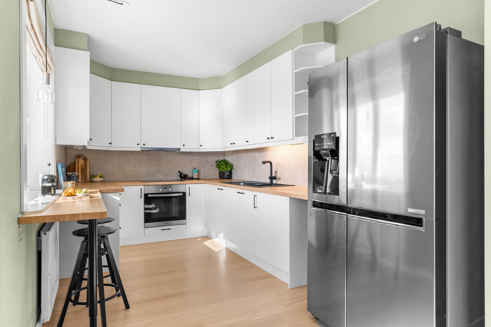 Kjøkkeninnredning har nye glatte fronter, skuffeinnsatser, sideplater, sokkel list, bakplate og ventilator fra 2024 Galleribilde