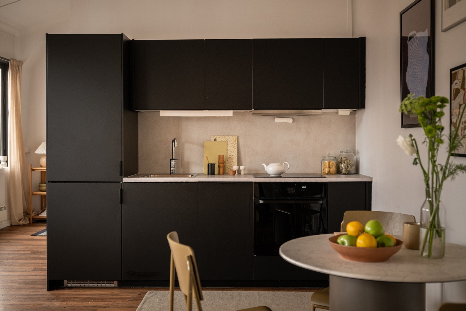 Stilrent og moderne Ikea-kjøkken som var nytt i 2021. Innredningen har sorte glatte fronter og laminert benkeplate med nedfelt oppvaskkum. Galleribilde