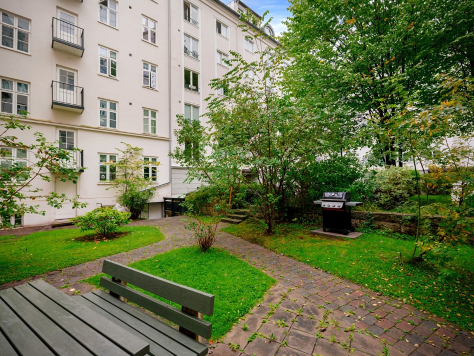 Pent opparbeidet bakgård med internveier og sittegrupper - Grill til benyttelse av beboerne. Galleribilde