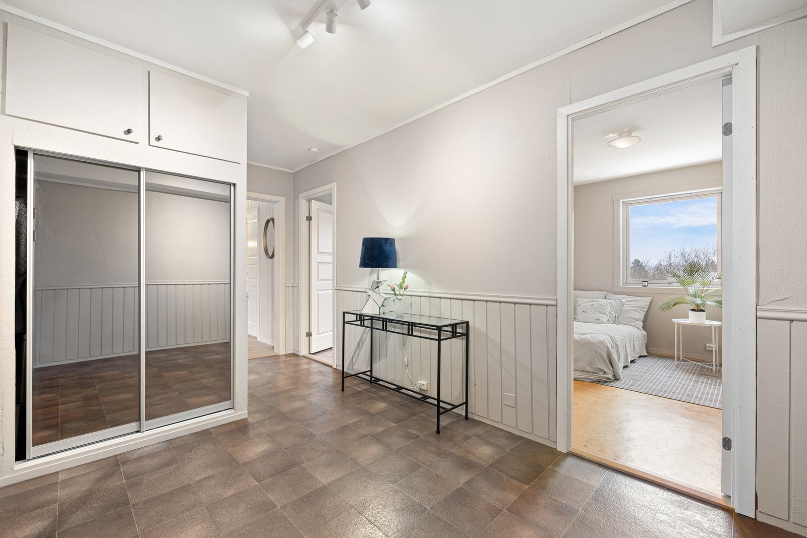 Lys og romslig entré med flislagt gulv og garderobeløsning. Galleribilde