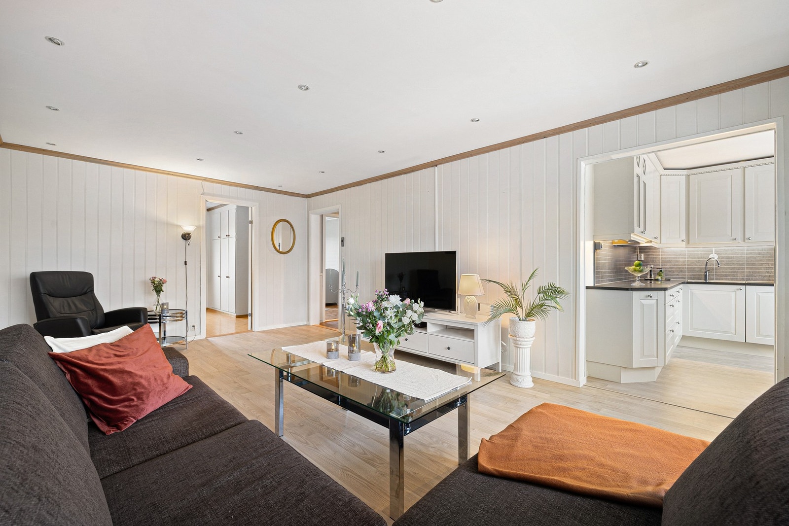 Leiligheten har et sosialt oppholdsrom med delvis åpen stue-/kjøkkenløsning. Galleribilde