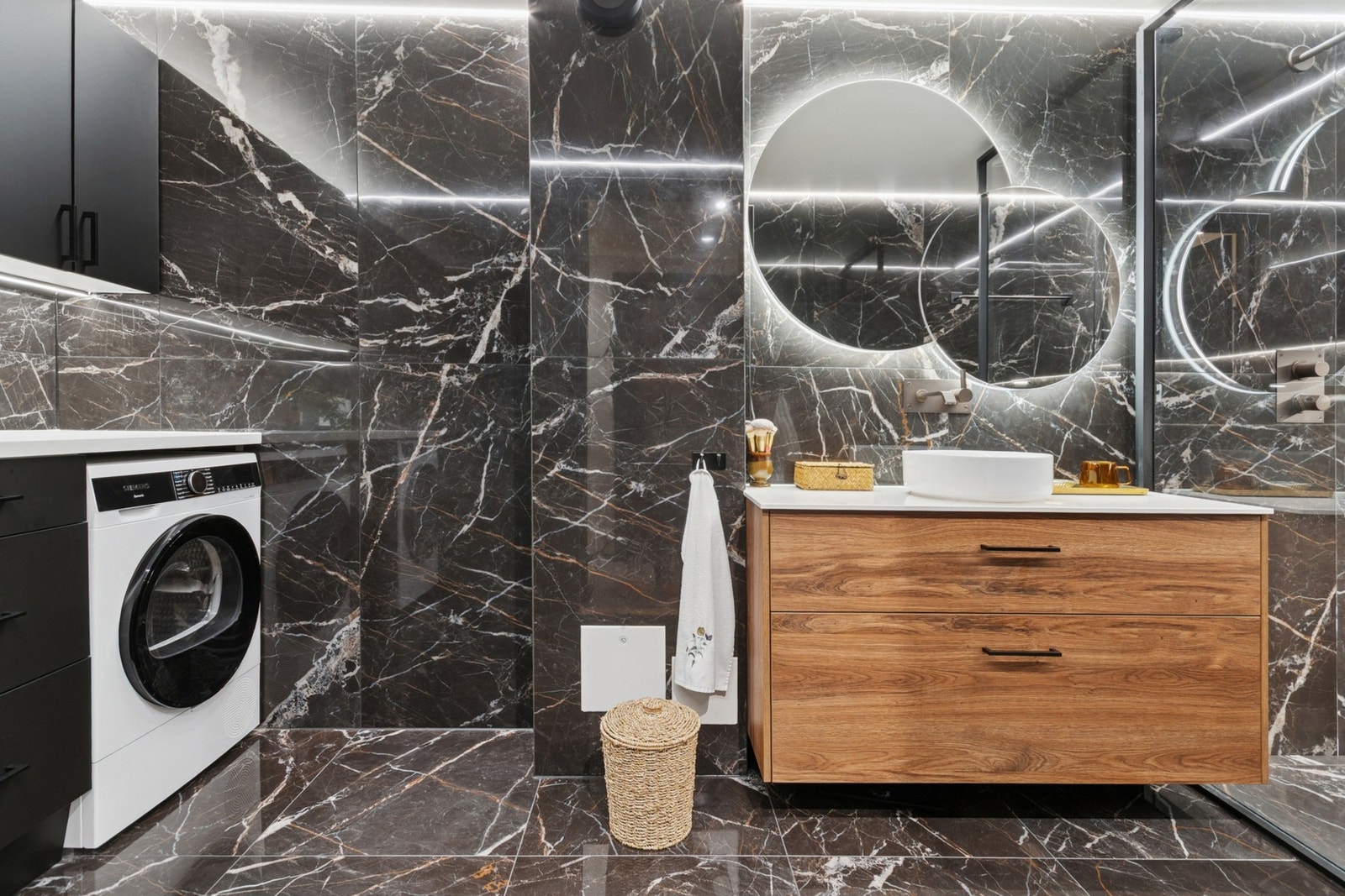 Badet er innredet med servant, dusjvegger/hjørne og opplegg for vaskemaskin. Galleribilde