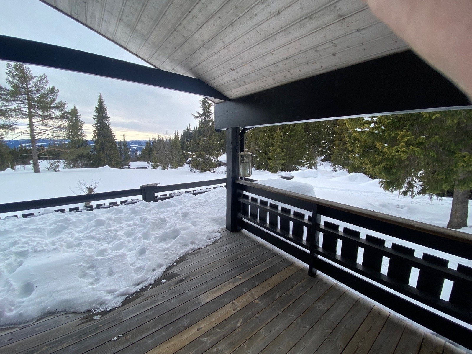 Romslig og delvis overbygd terrasse med utsikt utover omgivelsene. Galleribilde