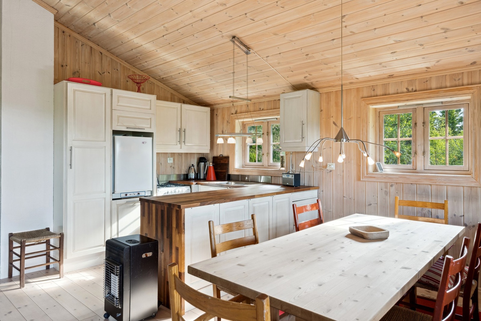 Lys kjøkkeninnredning med nedfelt oppvaskkum i heltre benkeplate. Galleribilde