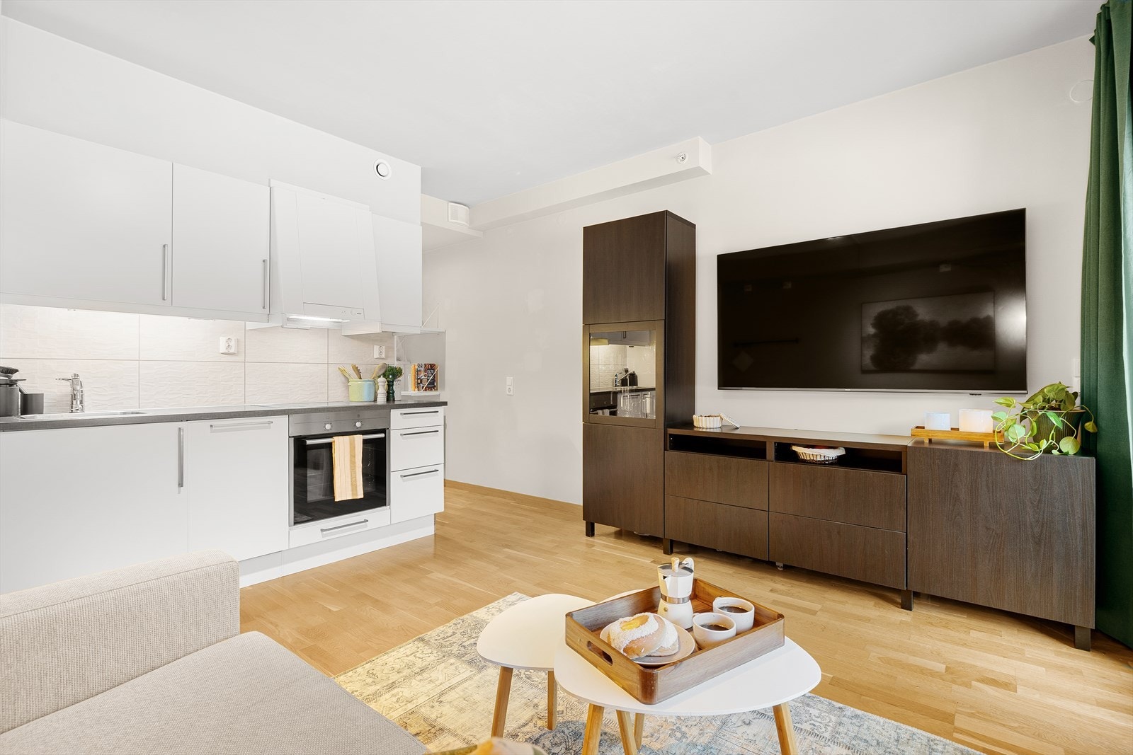 Hjemmets naturlige samlingspunkt er den åpne løsningen mellom stue og kjøkken på 14,5 m². Her er det plass til både sofaseksjon, spisebord og TV-vegg. Galleribilde