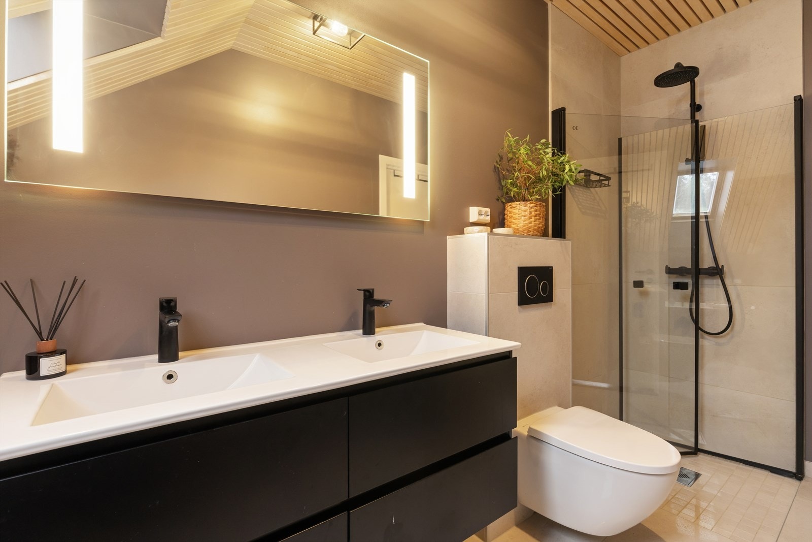 Badet har flislagte overflater, elektriske varmekabler i gulvet og vegghengt toalett. Galleribilde