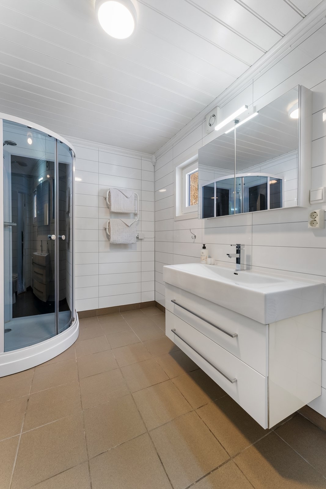 Bad i h-etg med flislagt golv, dusjkabinett og god oppbevaringsplass i skuffer og speilskap. Håndkletørker gir ein liten luksuskjensle i kvardagen! Galleribilde