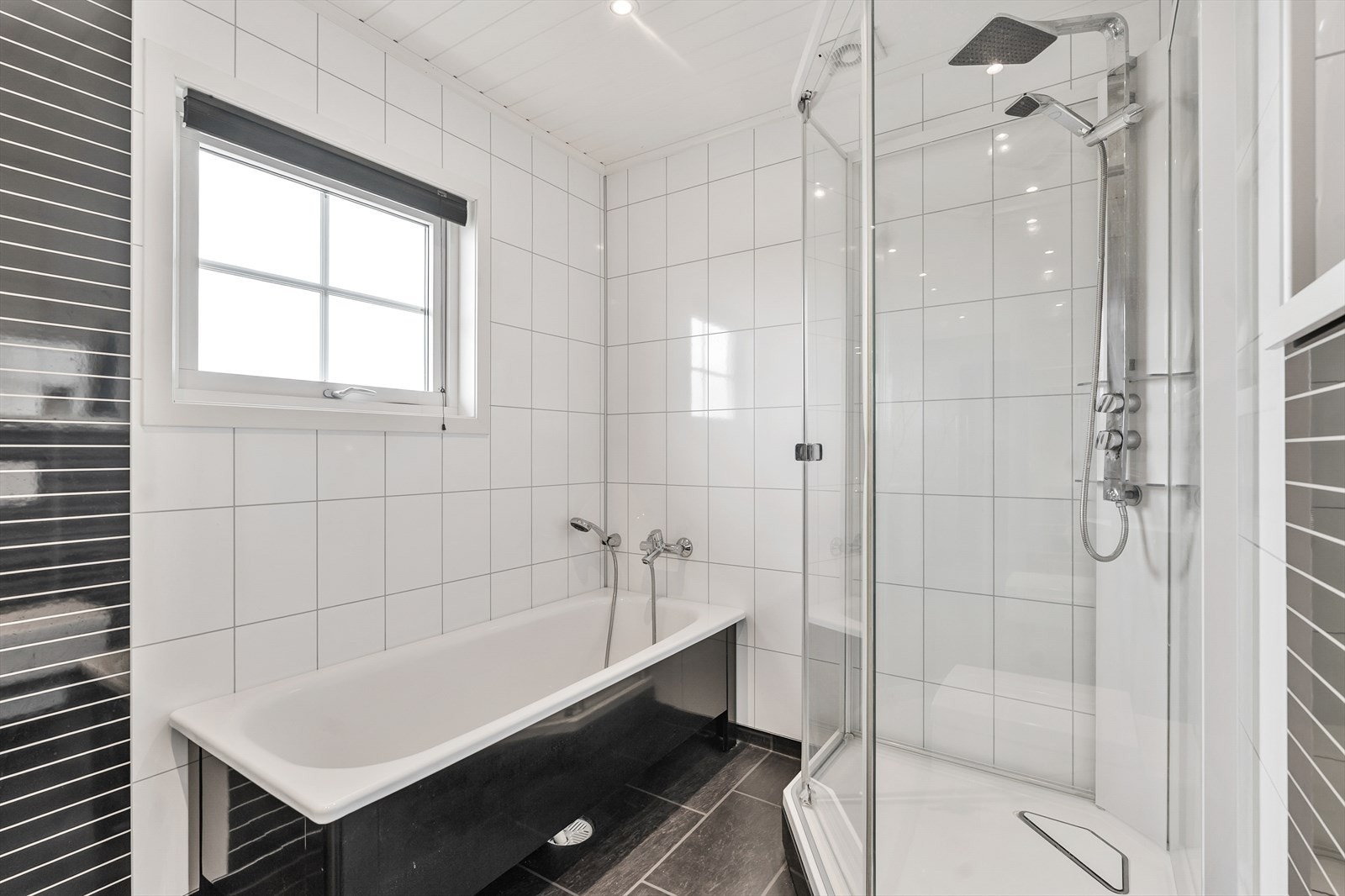 Rommet er innredet med nedfelt servant, vegghengt toalett, dusjkabinett og badekar Galleribilde