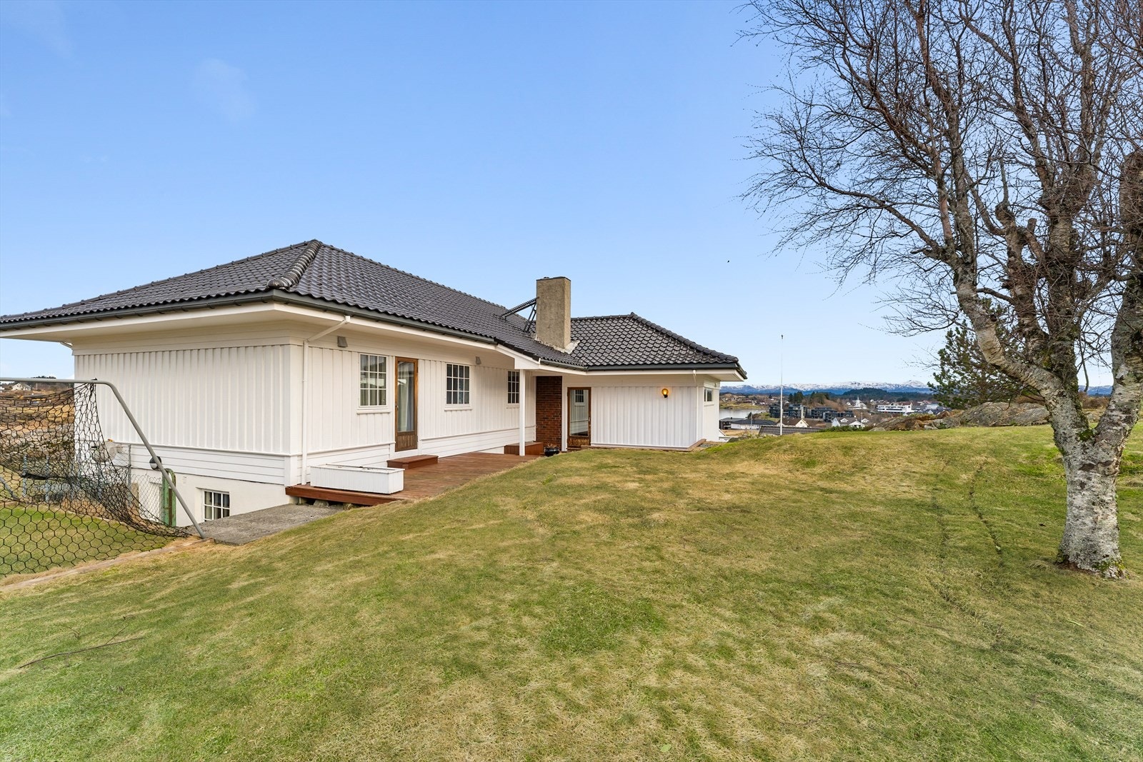 Tomten er pent opparbeidet, med plen og beplanting Galleribilde