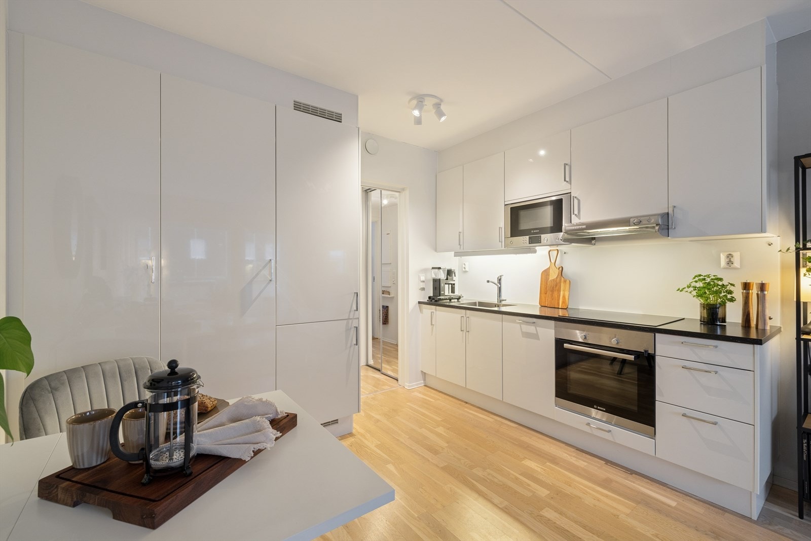 Kjøkkenet har innredning med glatte fronter og integrerte hvitevarer som platetopp, stekeovn, oppvaskmaskin, kjøl og frys. Galleribilde