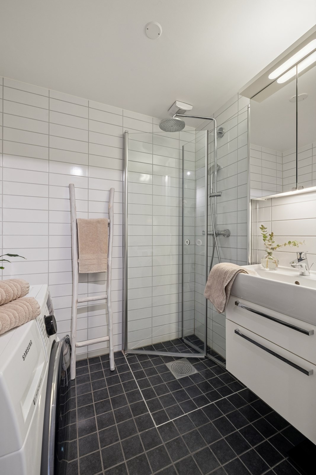 Flislagt bad fra byggeår, 2014, med elektriske varmekabler i gulv. Badet er utstyrt med servant med innredning, speilskap, vegghengt toalett, dusjhjørne med glassvegger og opplegg for vaskemaskin. Galleribilde