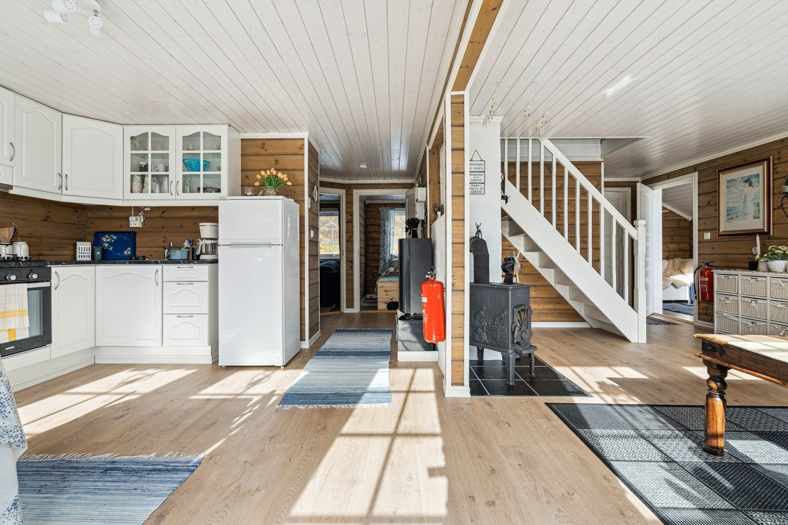 Kjøkken og del av stuen med trapp opp til loft Galleribilde