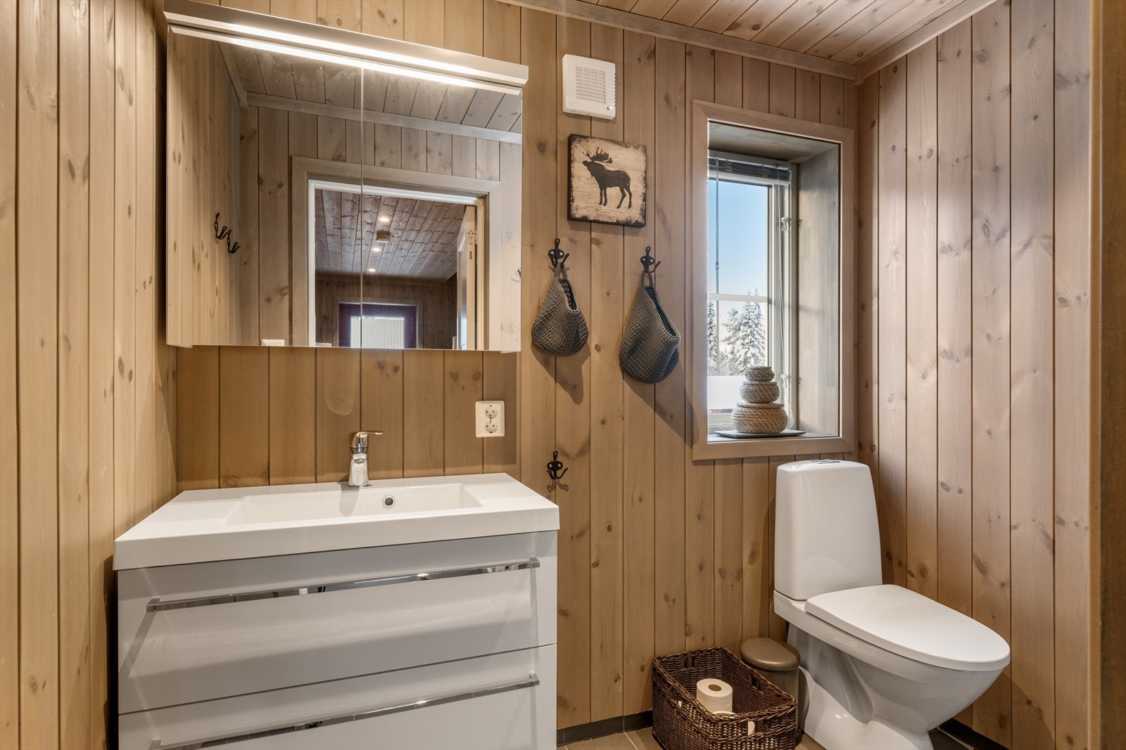 Badet har panelte og dels flislagte vegger og flislagt gulv med gulvvarme. Galleribilde