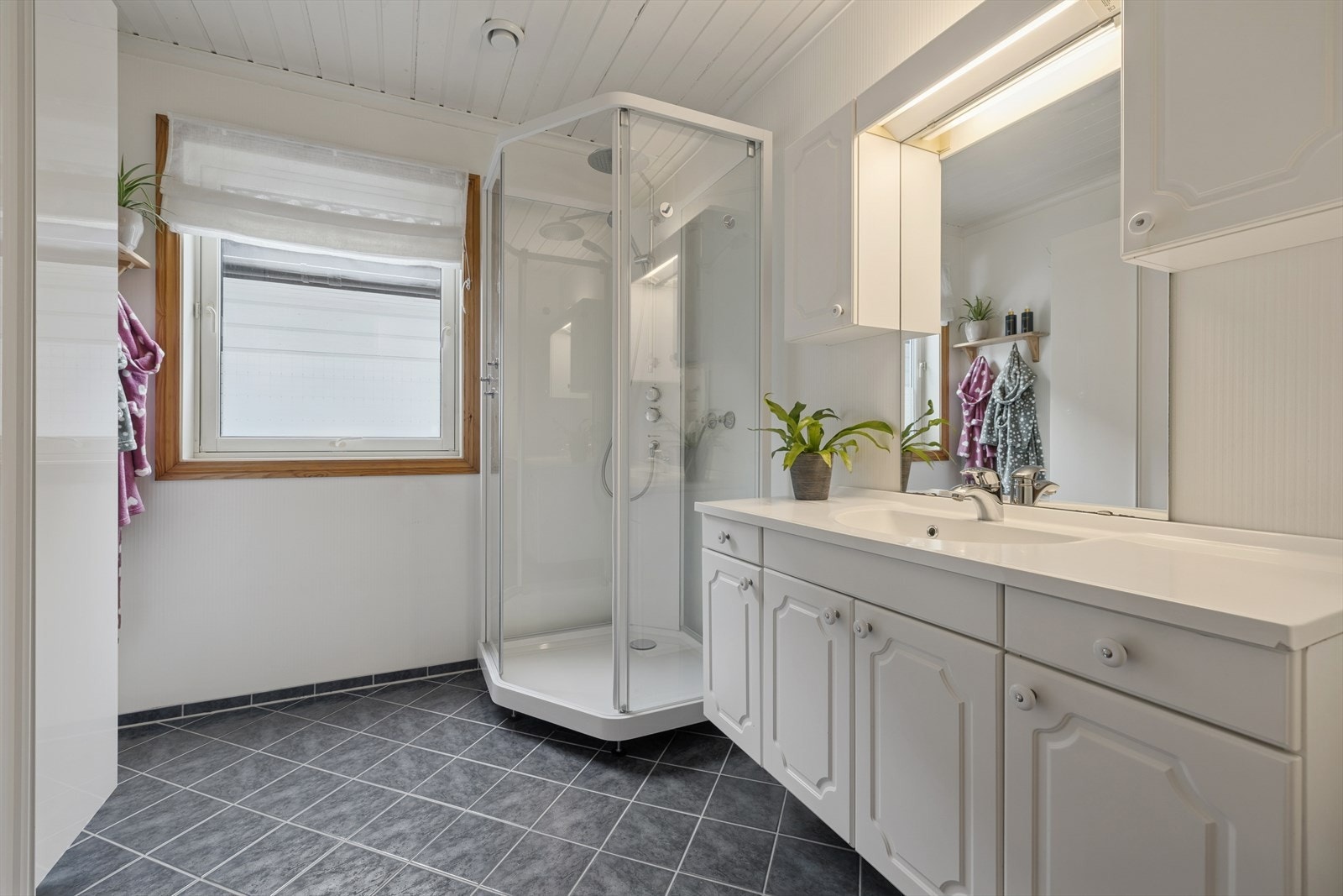 Bad med fliser på gulv og gulvvarme. Innredning med nedfelt servant, toalett og dusjkabinett. Galleribilde