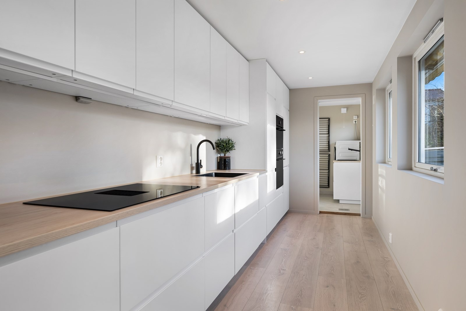 Stilrent kjøkken med mye god lagringsplass. Ikea-kjøkken. Kjøkken mot vaskerom. Galleribilde