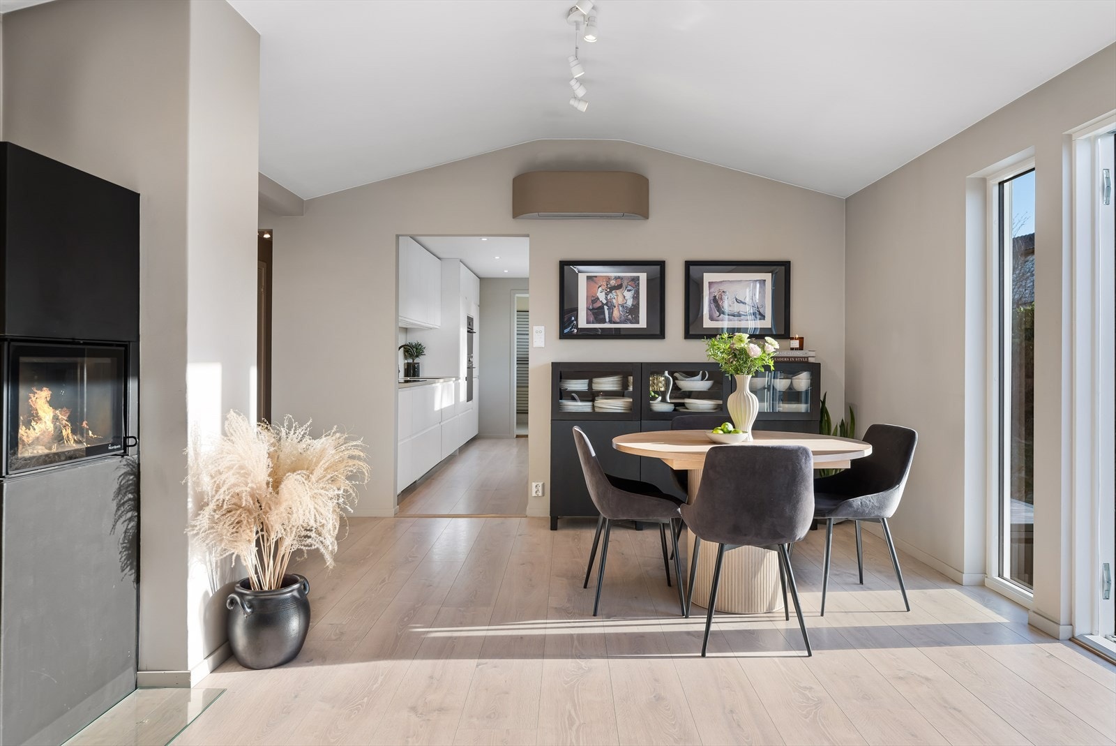 God plass til spisestue, moderne og reintbrennende peisovn. Ser mot åpen løsning mot kjøkken. Galleribilde