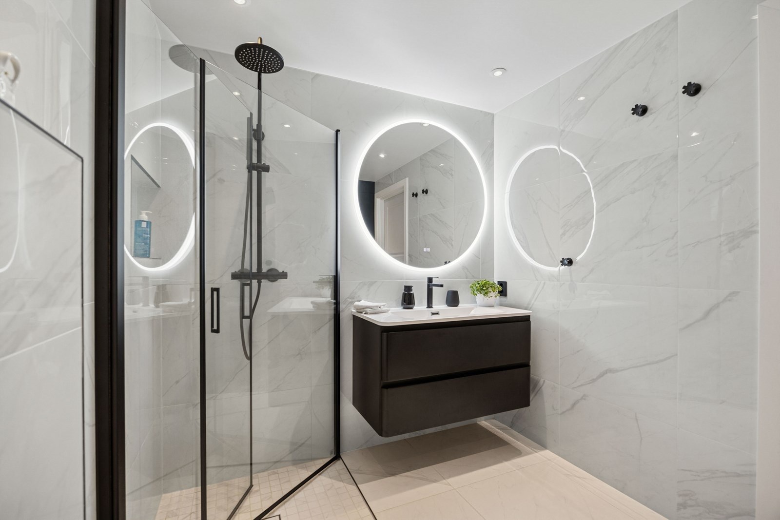 Badet er innredet med vegghengt toalett, servant med innredning, dusj og opplegg for vaskemaskin. Galleribilde