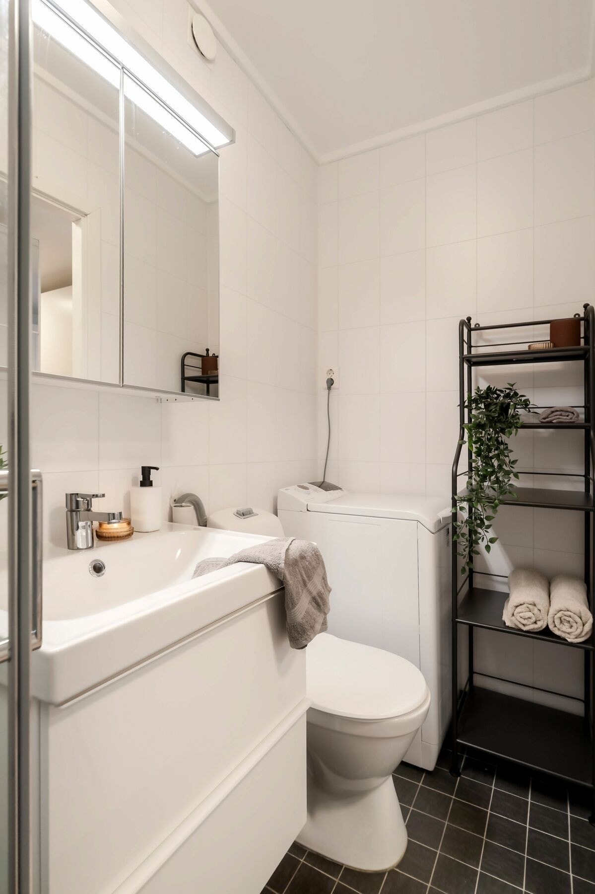 Badet er utstyrt med dusjhjørne, servant, opplegg for vaskemaskin og toalett samt mulighet for smart oppbevaringsløsning. Galleribilde