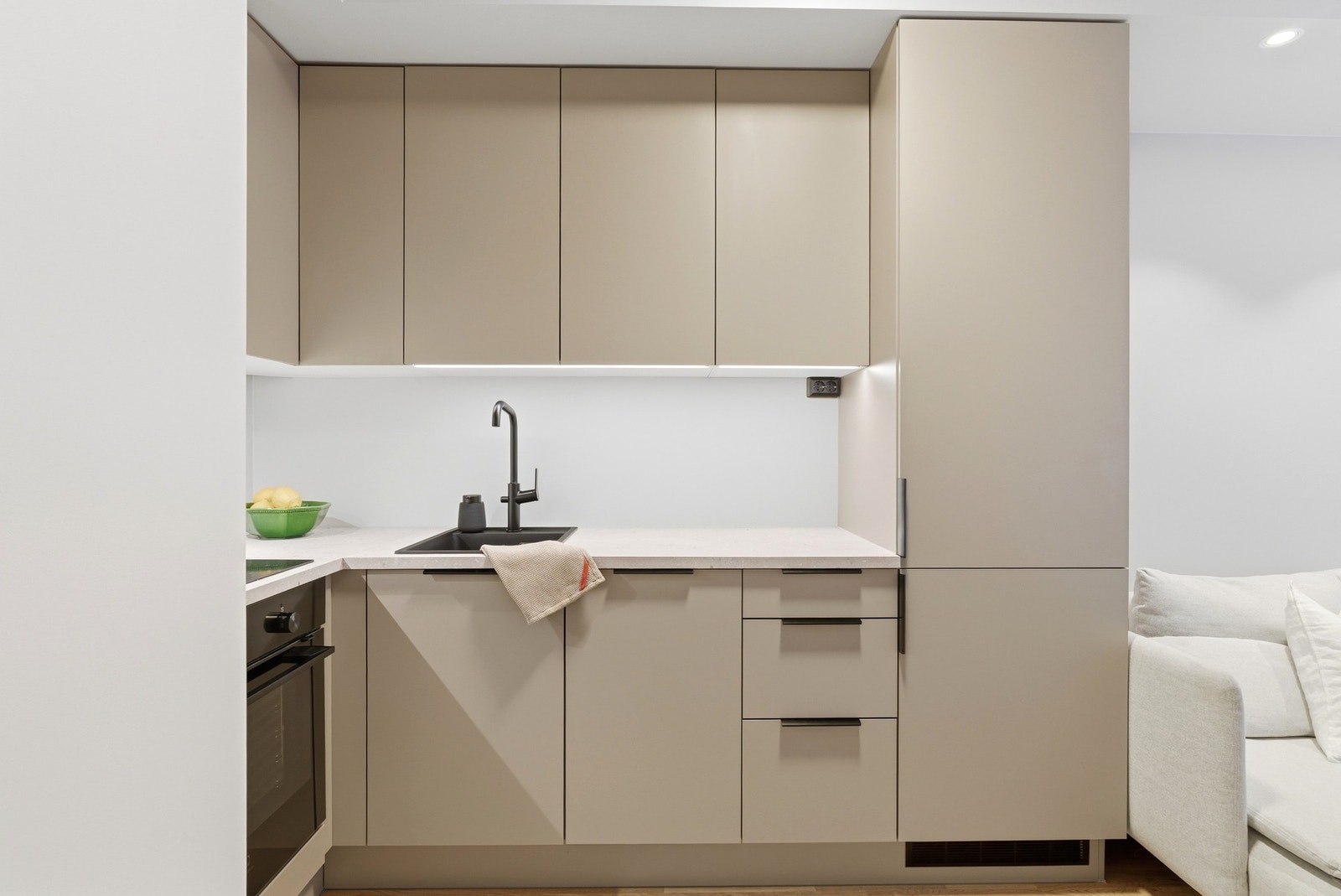 Slette fronter, benkeplate av laminat og sorte detaljer. Ledstriper under overskap. Galleribilde