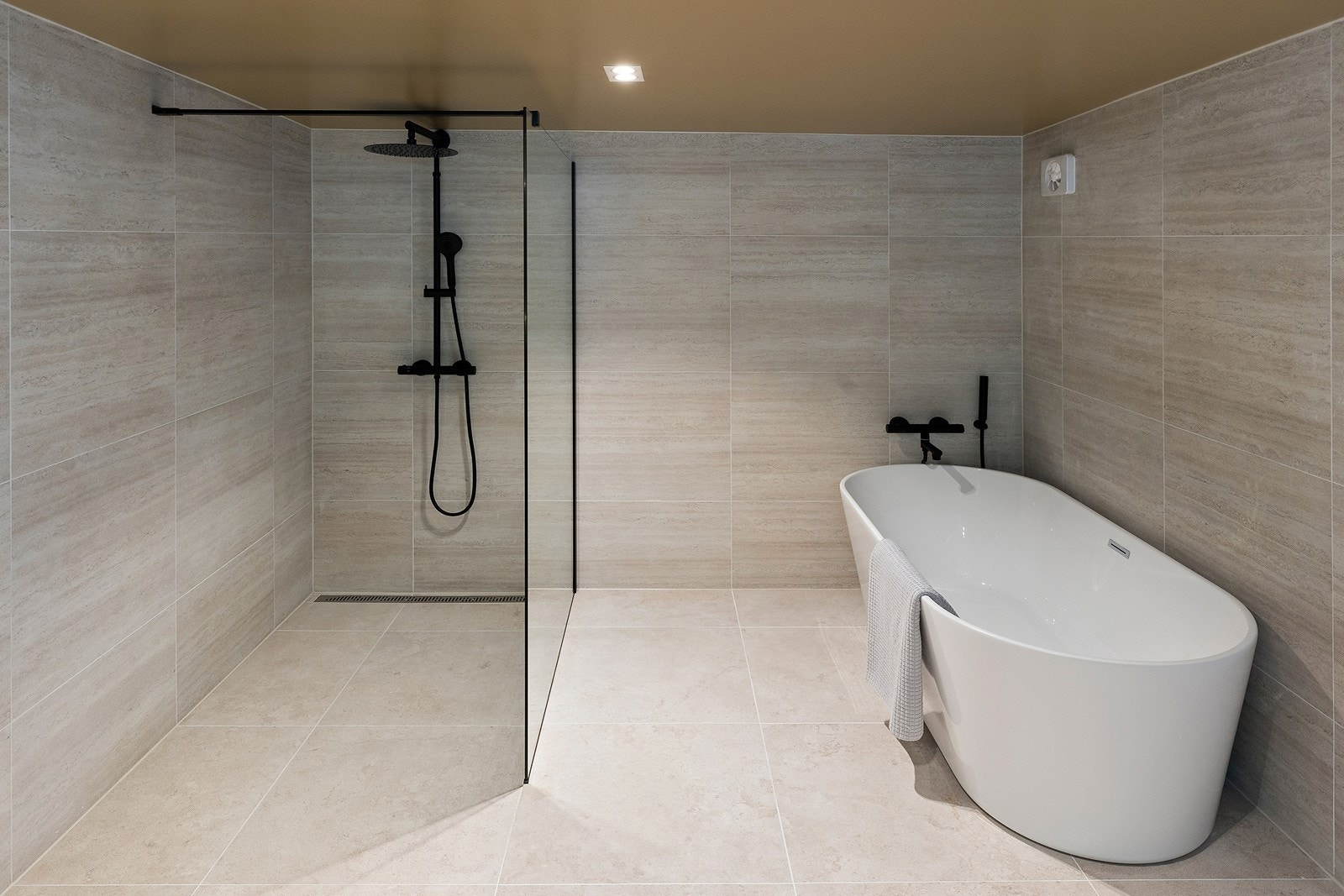 Også dette baderommet har store, flotte fliser på gulv og vegger Galleribilde