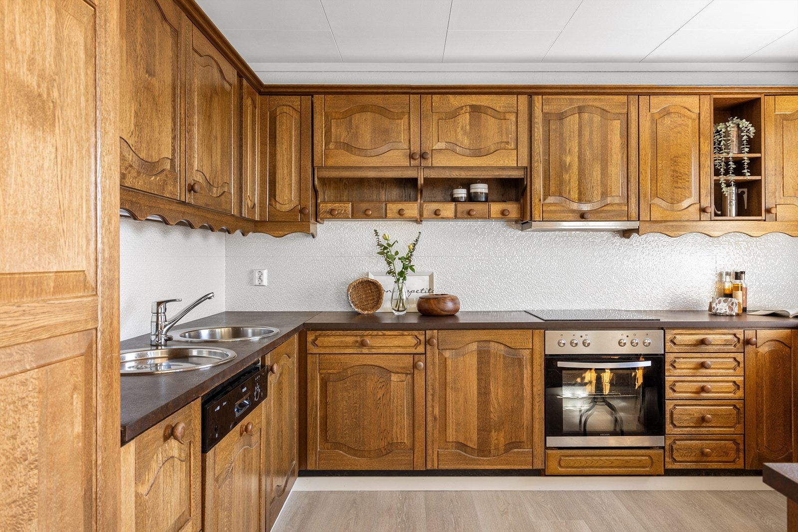 Innredning med profilerte fronter i heltre og integrerte hvitevarer. Galleribilde