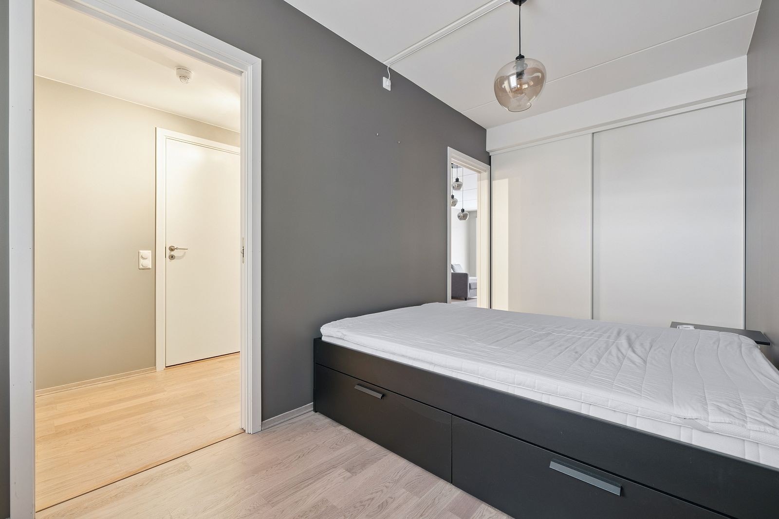 Soverom med plass til dobbeltseng og garderobeløsning, malt i rolige fargetoner. Galleribilde