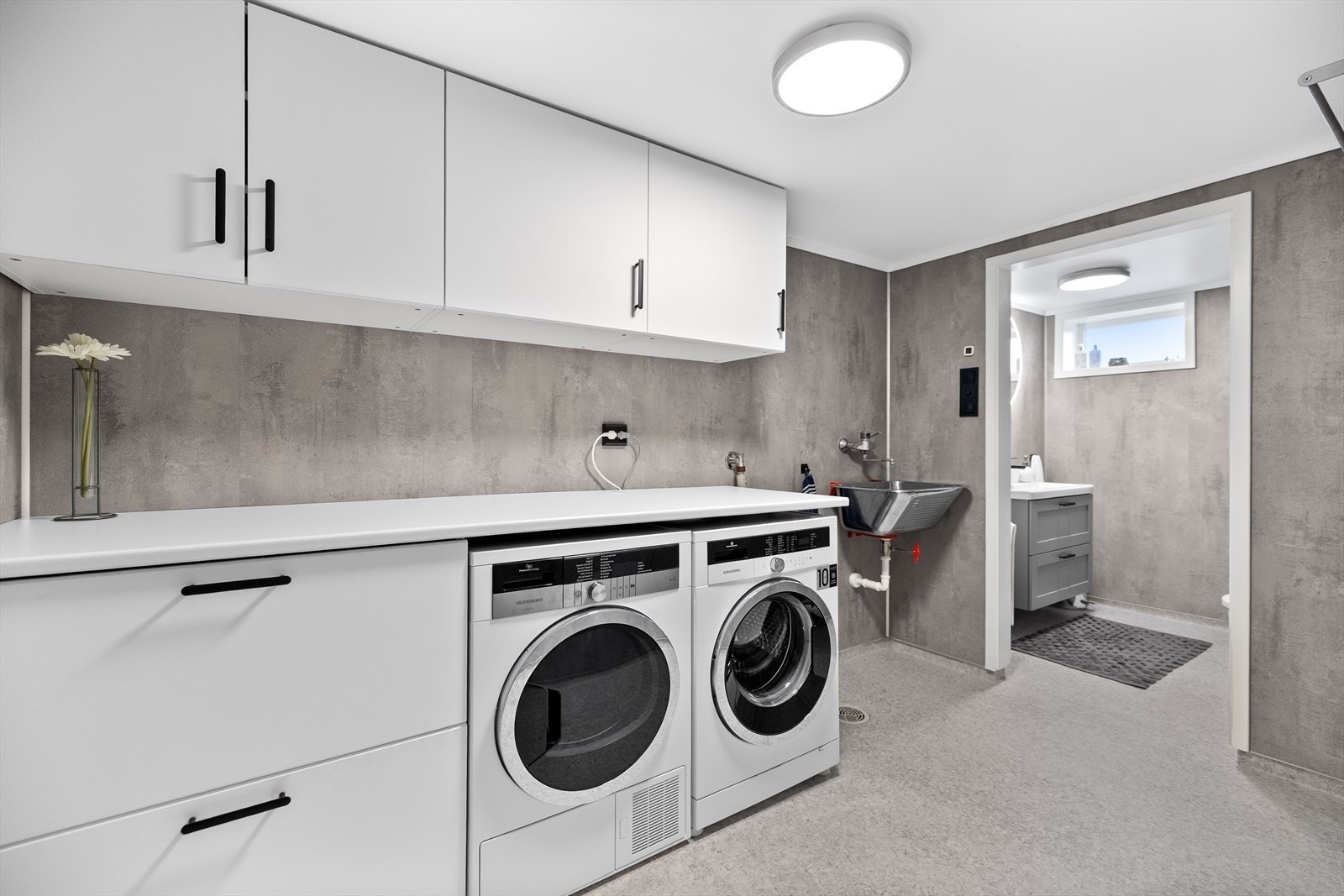 I kjelleren ligger et praktisk bad/vaskerom med baderomsplater på veggene og belegg på vinylgulv (belegget er helsveiset). Opplegg for vaskemaskin og tørketrommel Galleribilde