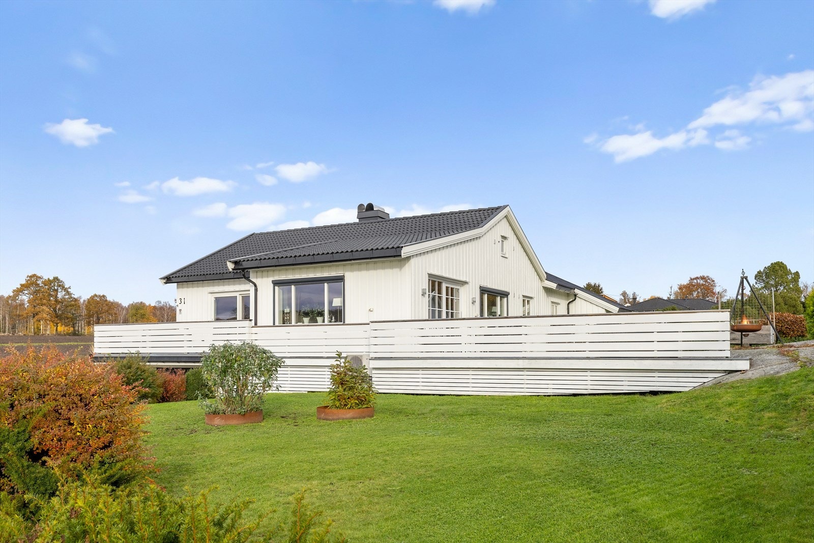 Boligen har en flott hage med plen, busker og hekk. Galleribilde