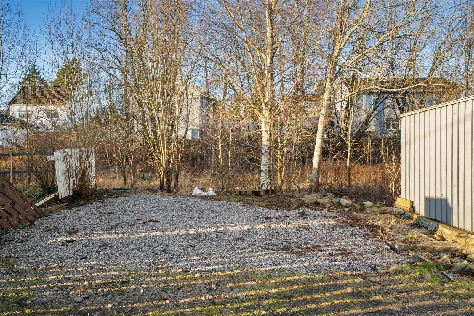 Gruset gårdsplass med parkeringsmuligheter. Galleribilde