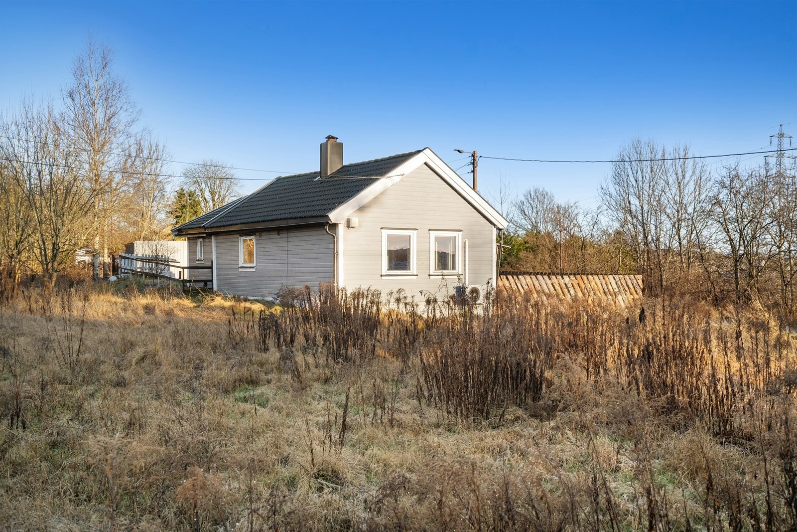 Tomten er er delvis inngjerdet og består av plenareal og gruset gårdsplass. Galleribilde