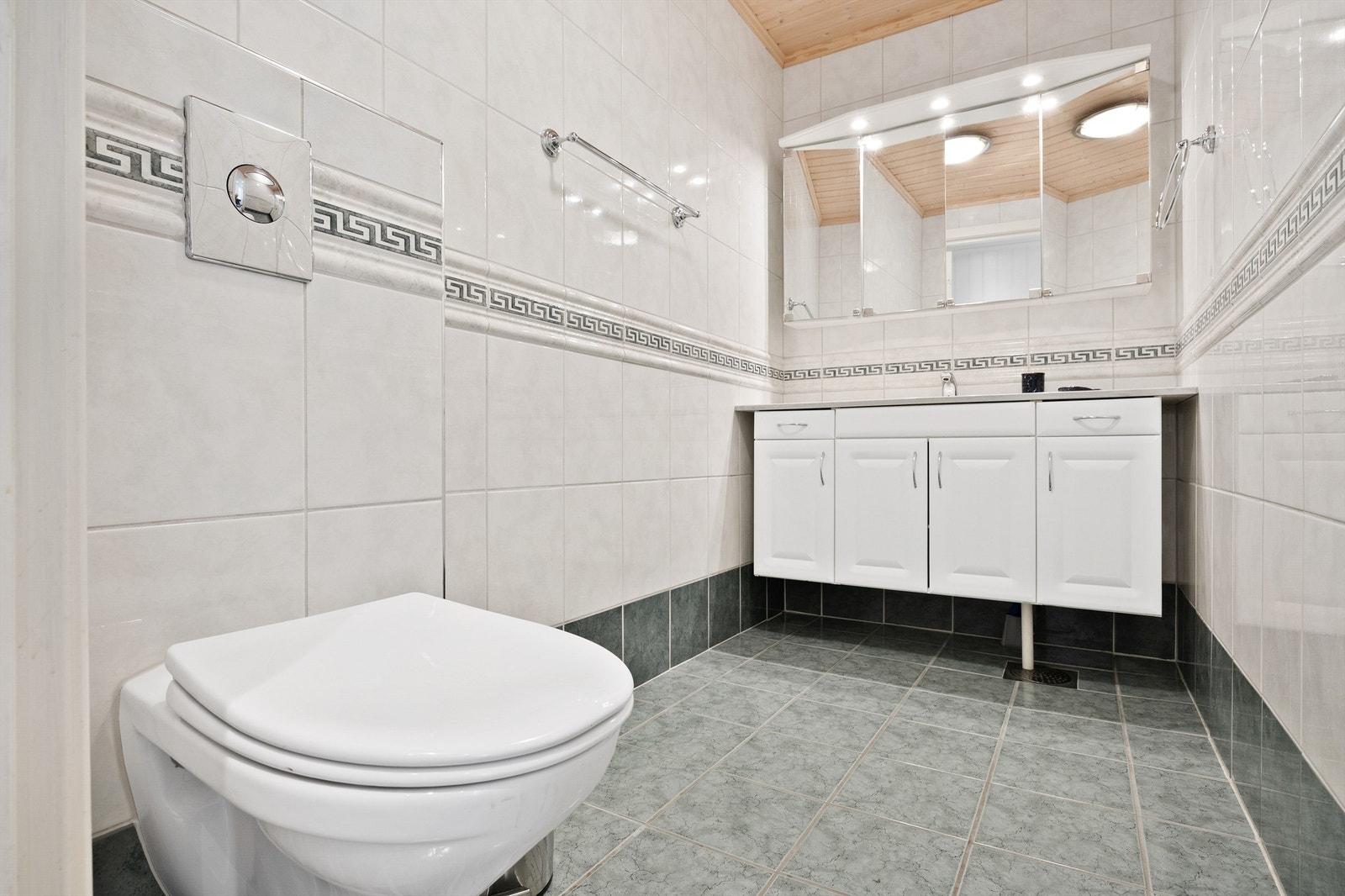 Toalettrom med vegghengt toalett og servant i innredning. Galleribilde