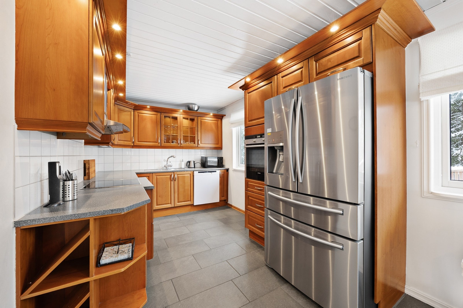 Kjøkkenet tilbyr godt med arbeidsplass på benkeplaten og rikelig med skapplass Galleribilde