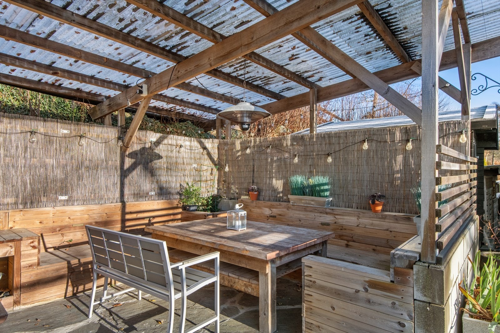 Overbygget uteplass gir ly for vær og vind, med plass til sittegruppe og grillutstyr for sosiale sammenkomster. Galleribilde