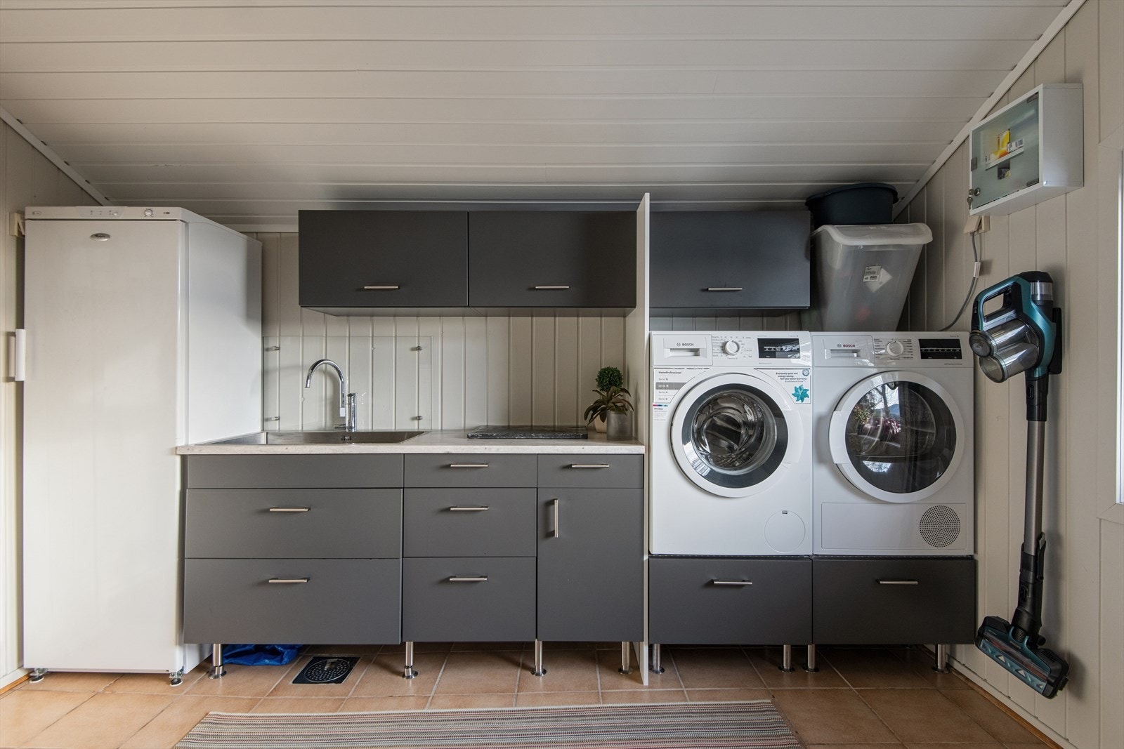 Vaskerommet er praktisk innredet med skap og benkeplass. Det er plass til både vaskemaskin og tørketrommel. Galleribilde