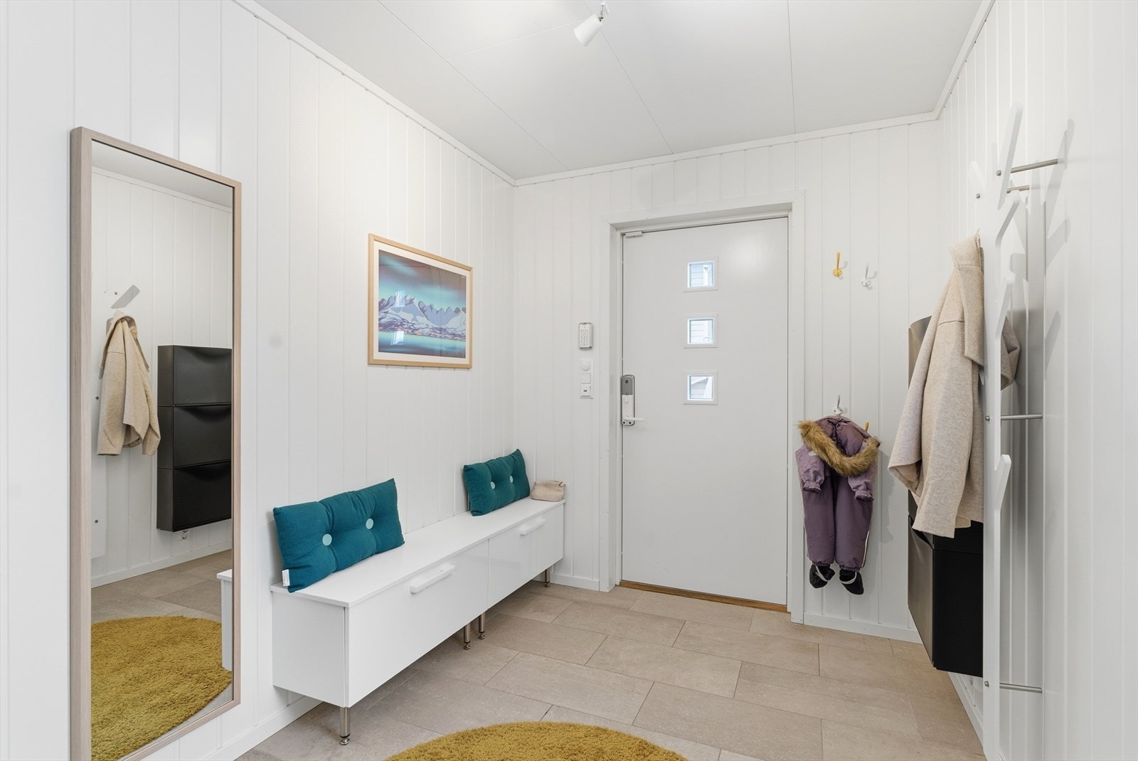 Her er det praktisk og pent flislagt gulv, samt en større skyvedørsgarderobe som gir god plass til oppbevaring av yttertøy og sko. Galleribilde