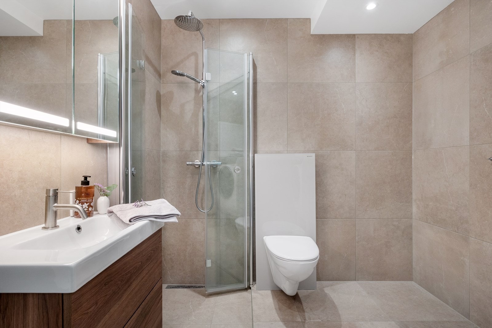 Flislagte overflater og dusjhjørne med glassvegger gir et stilrent bad. Galleribilde